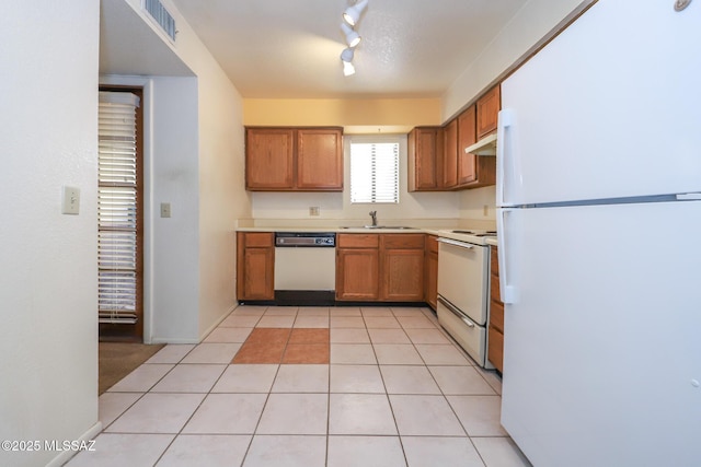 kitchen with sink, light tile patterned floors, track lighting, and white appliances