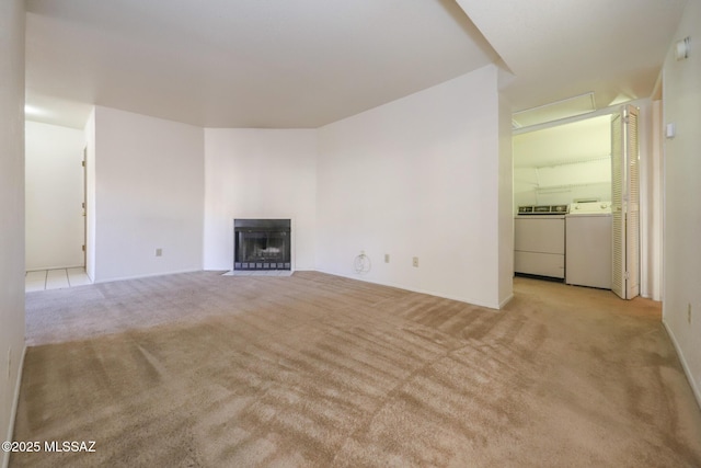 unfurnished living room with light carpet and washer and clothes dryer