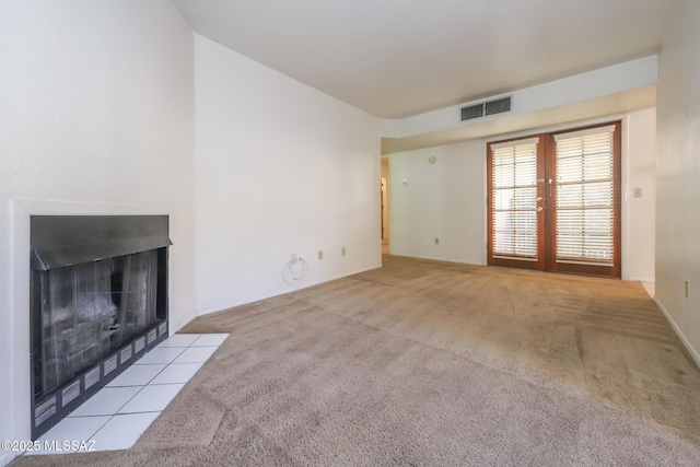 unfurnished living room with a fireplace and light colored carpet