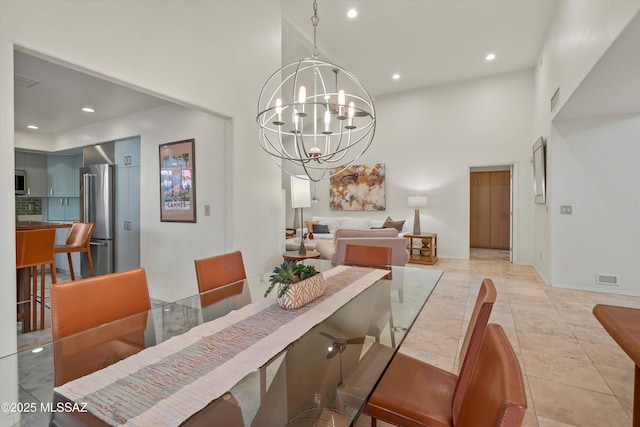 tiled dining area with a notable chandelier and a towering ceiling