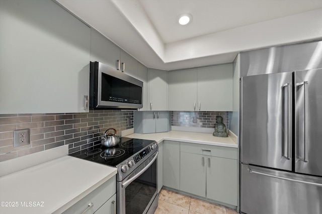 kitchen with decorative backsplash, light tile patterned floors, appliances with stainless steel finishes, and gray cabinetry