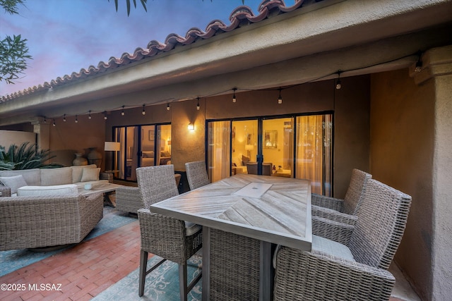 patio terrace at dusk featuring an outdoor living space