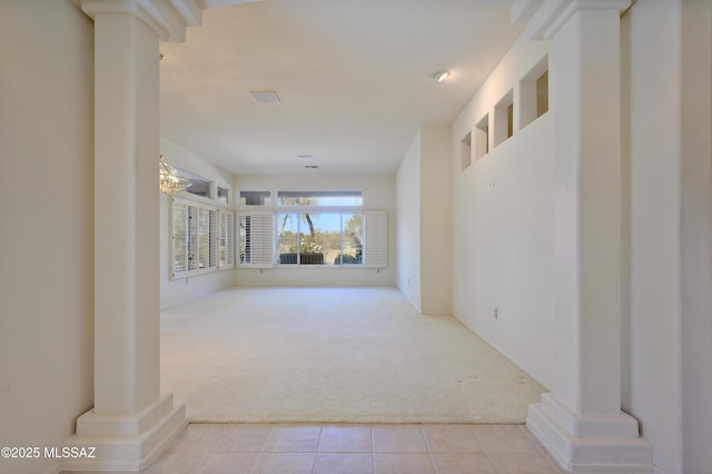 corridor with light carpet and decorative columns