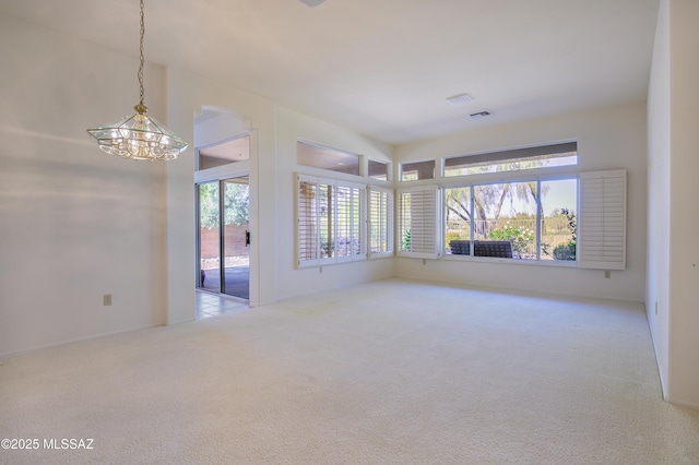 empty room featuring light carpet and an inviting chandelier