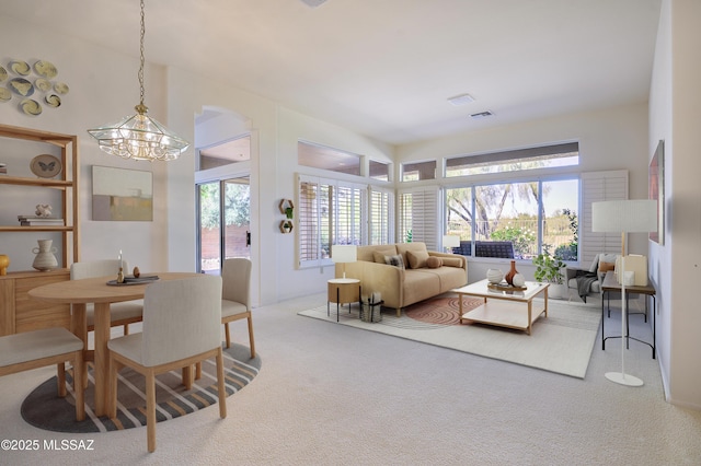 living room with an inviting chandelier and carpet flooring