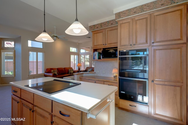 kitchen with a kitchen island, double oven, hanging light fixtures, light tile patterned floors, and black electric cooktop