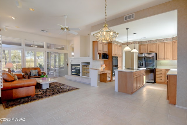 kitchen featuring black appliances, a center island, hanging light fixtures, decorative backsplash, and light tile patterned flooring