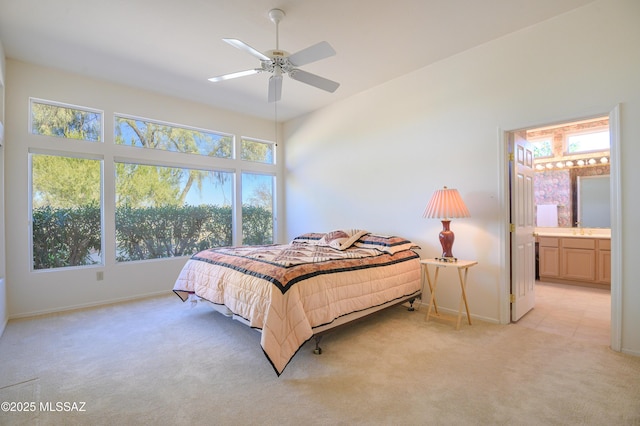 bedroom featuring light carpet, connected bathroom, and ceiling fan