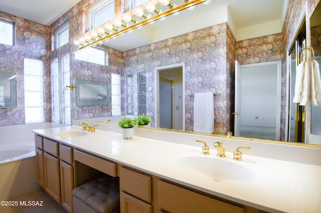 bathroom with a tub to relax in, tile patterned flooring, and vanity