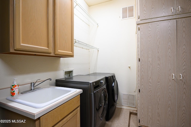 laundry area featuring sink, washer and clothes dryer, and cabinets