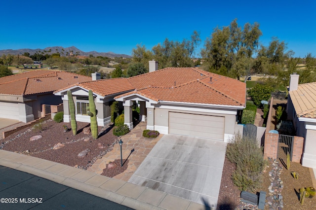 mediterranean / spanish house featuring a garage and a mountain view