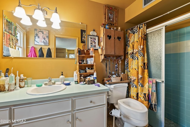 bathroom featuring toilet, tiled shower, and vanity