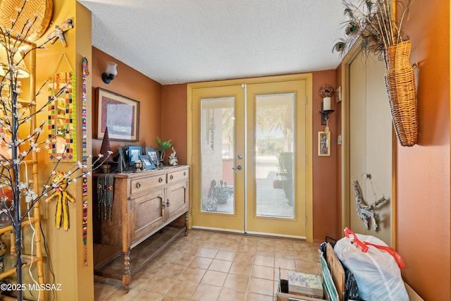 doorway to outside with a textured ceiling, french doors, and light tile patterned flooring