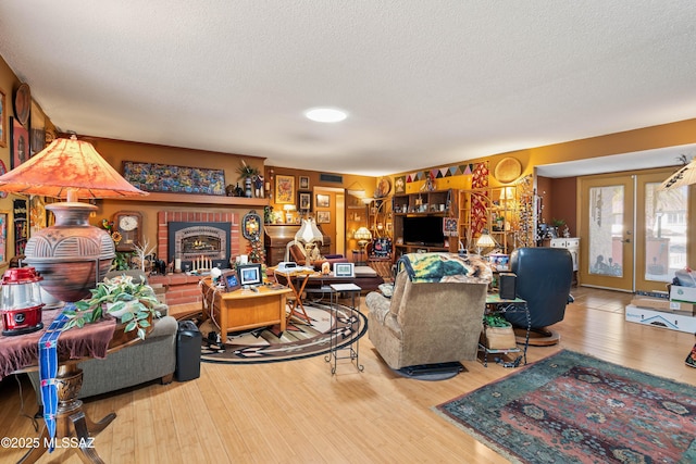 living room featuring french doors, a textured ceiling, and light hardwood / wood-style flooring