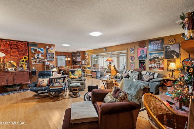 living room with a textured ceiling and light hardwood / wood-style floors