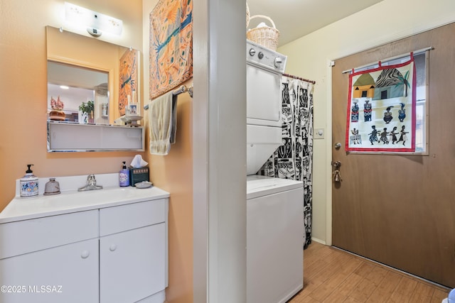 washroom with stacked washing maching and dryer, light wood-type flooring, and sink