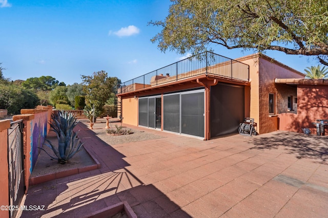 back of house featuring a patio area and a balcony