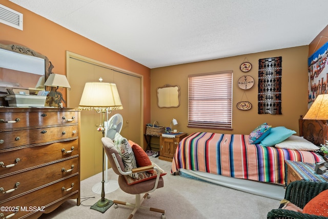 bedroom featuring a closet, a textured ceiling, and light carpet