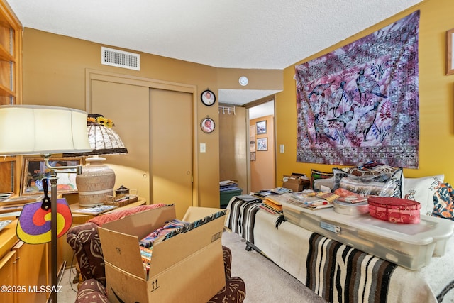 carpeted bedroom featuring a textured ceiling and a closet