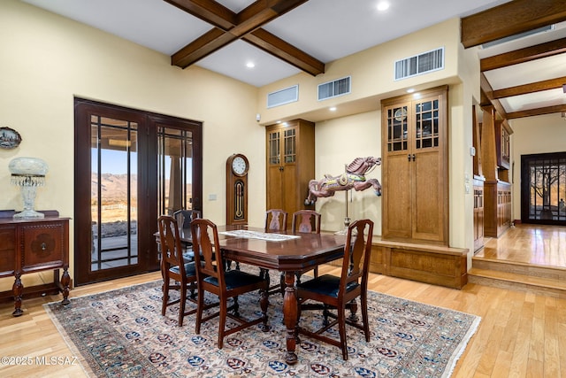 dining room featuring coffered ceiling, light wood-type flooring, beam ceiling, and french doors