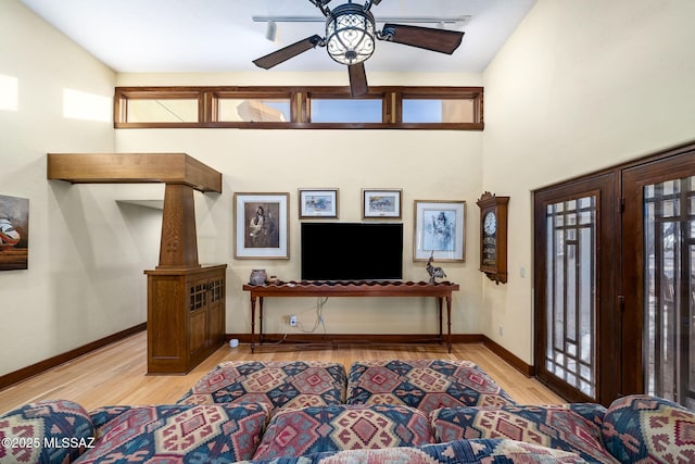 entrance foyer with ceiling fan, light hardwood / wood-style floors, and a high ceiling