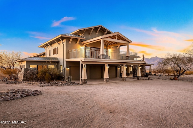 view of front of property with a mountain view, a garage, and a balcony