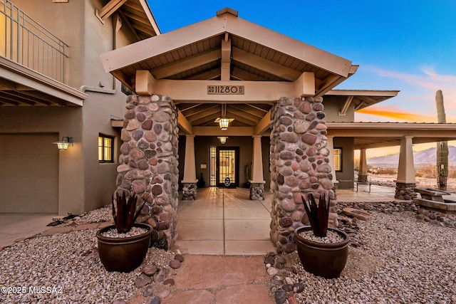 exterior entry at dusk featuring a garage