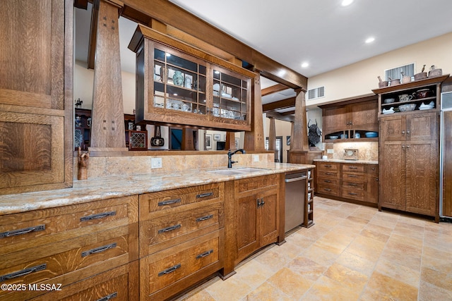 kitchen featuring ornate columns, light stone countertops, sink, and stainless steel dishwasher