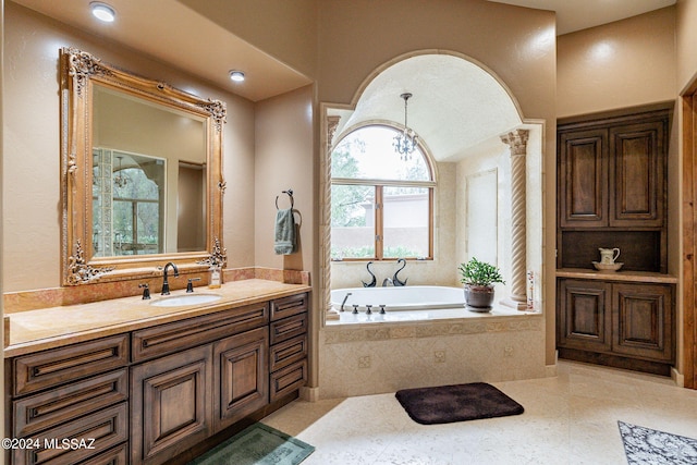 bathroom with vanity, tile patterned floors, and tiled bath