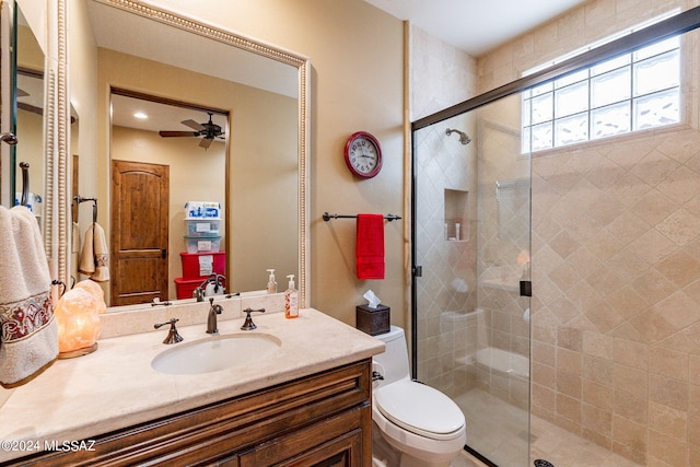 bathroom with ceiling fan, walk in shower, vanity, and toilet