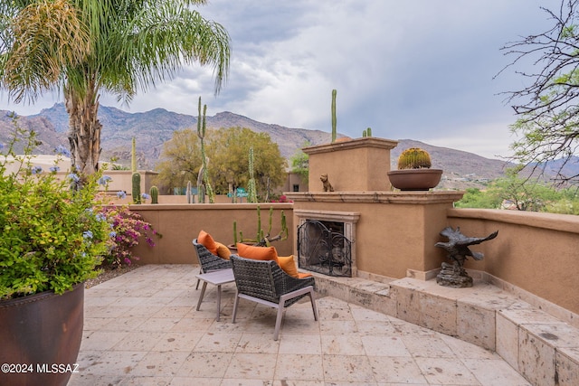 view of patio featuring an outdoor fireplace and a mountain view