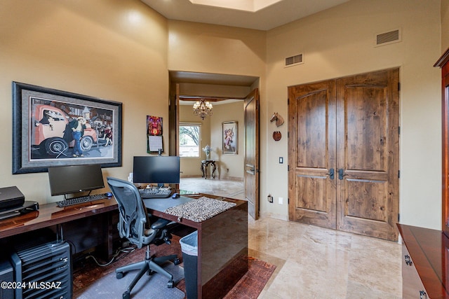 office featuring a towering ceiling and an inviting chandelier