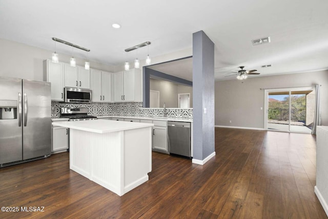 kitchen with white cabinetry, ceiling fan, hanging light fixtures, dark hardwood / wood-style floors, and appliances with stainless steel finishes