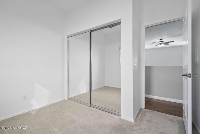 unfurnished bedroom featuring light colored carpet and a closet