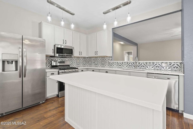 kitchen featuring white cabinets, stainless steel appliances, dark wood-type flooring, a kitchen island, and sink