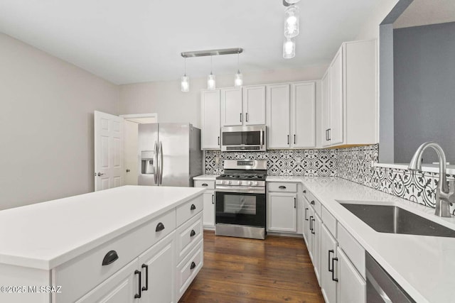 kitchen with white cabinets, appliances with stainless steel finishes, hanging light fixtures, and sink