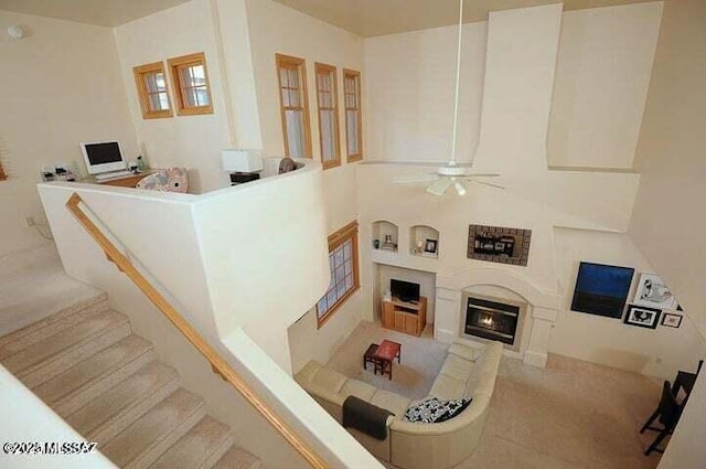 living room with ceiling fan and built in shelves