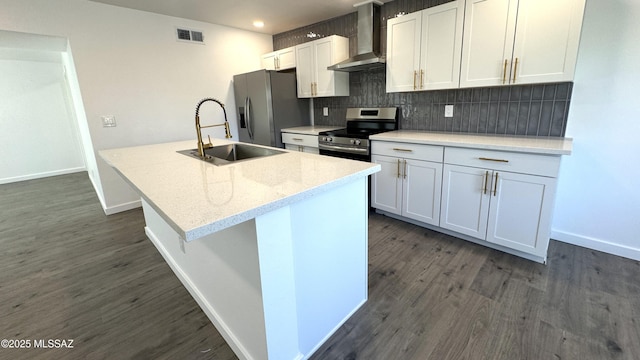 kitchen featuring appliances with stainless steel finishes, white cabinetry, wall chimney range hood, and decorative backsplash