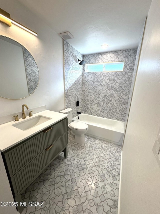 full bathroom with toilet, vanity, and tiled shower / bath