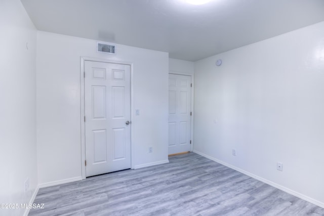 unfurnished bedroom with a closet and light hardwood / wood-style floors