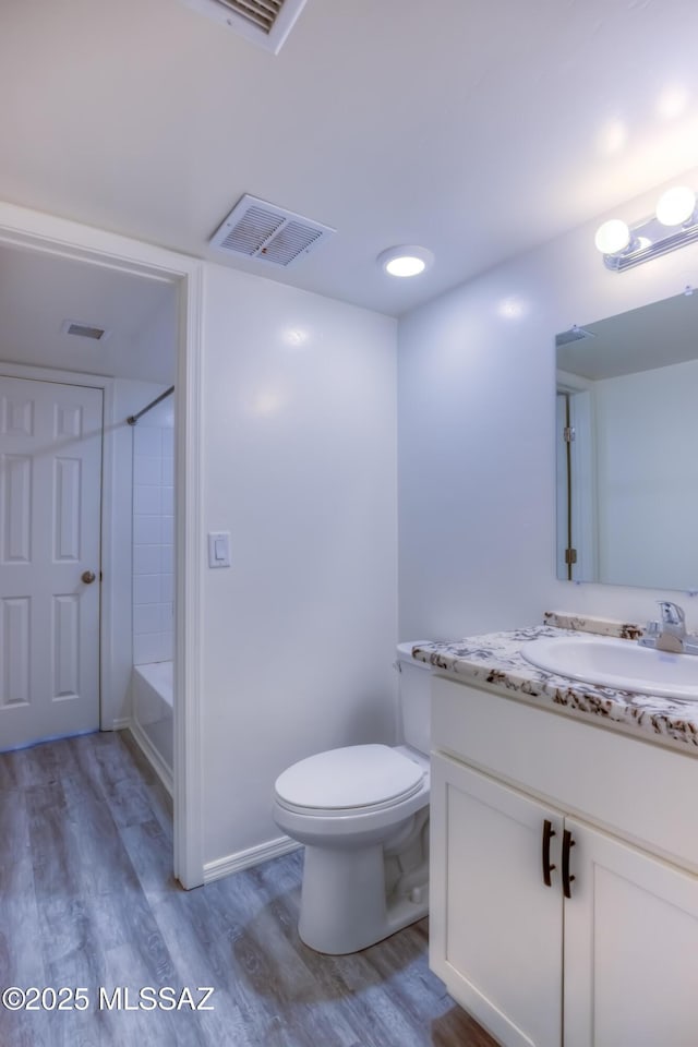 full bathroom with tub / shower combination, hardwood / wood-style floors, toilet, and vanity