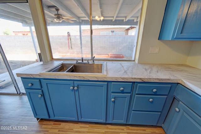 kitchen featuring ceiling fan, light hardwood / wood-style flooring, and blue cabinetry