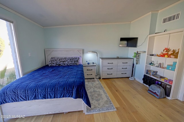 bedroom with crown molding and light hardwood / wood-style flooring