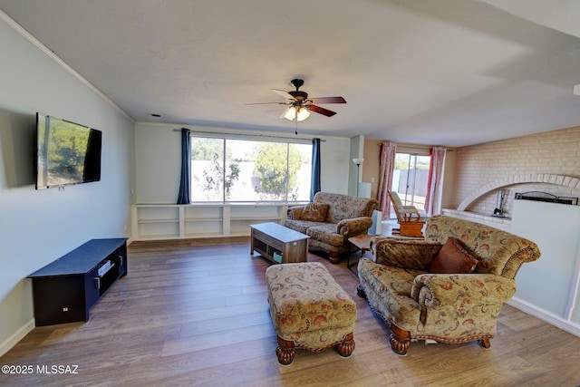 living room with vaulted ceiling, ceiling fan, ornamental molding, and dark hardwood / wood-style flooring