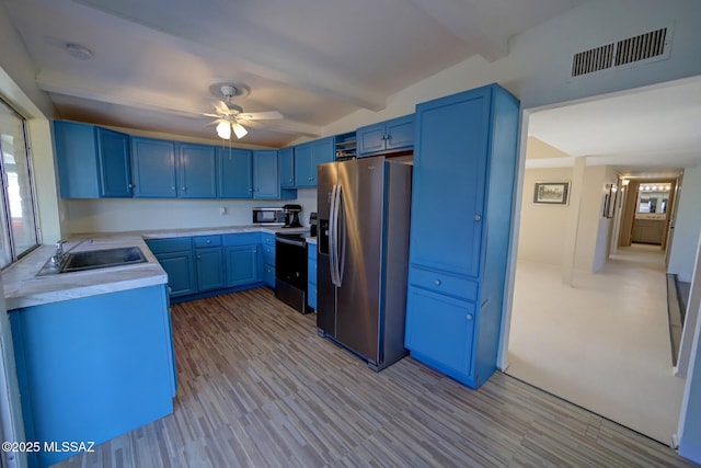 kitchen featuring beamed ceiling, ceiling fan, stainless steel fridge, sink, and blue cabinets