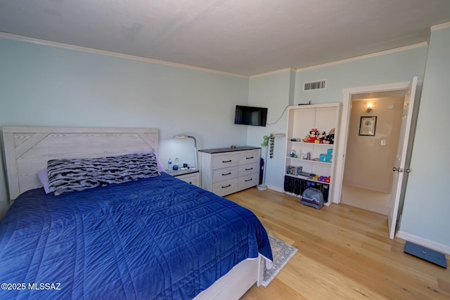 bedroom with light hardwood / wood-style floors and crown molding