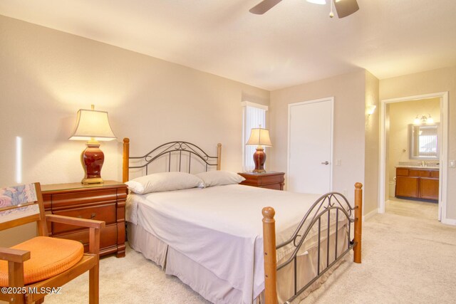 carpeted bedroom with ceiling fan, sink, and ensuite bath