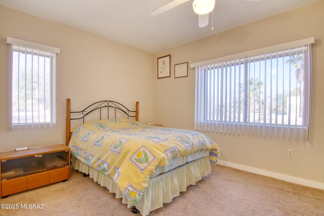 carpeted bedroom with ceiling fan and multiple windows