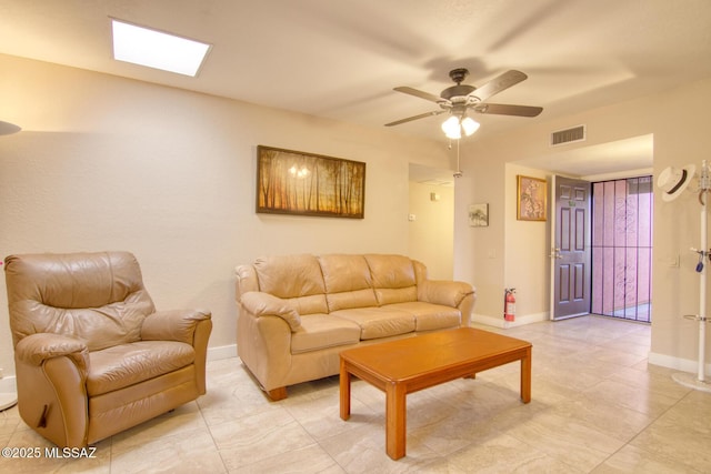 living room with ceiling fan and a skylight