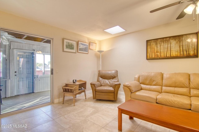 living room featuring ceiling fan and a skylight